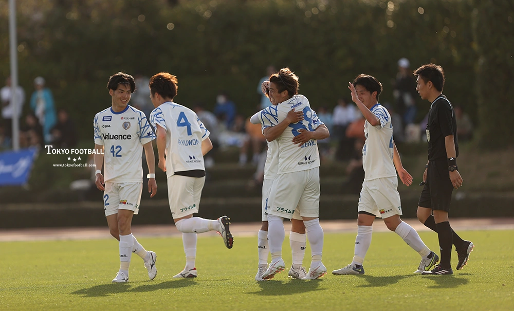 写真：前半にゴールを決めて祝福されるFW大前（中央）。