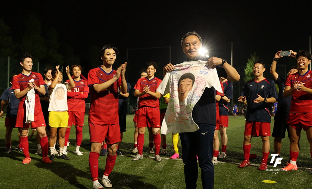 写真:主将の関野からメッセージ入りのTシャツを受け取る漆間監督。
